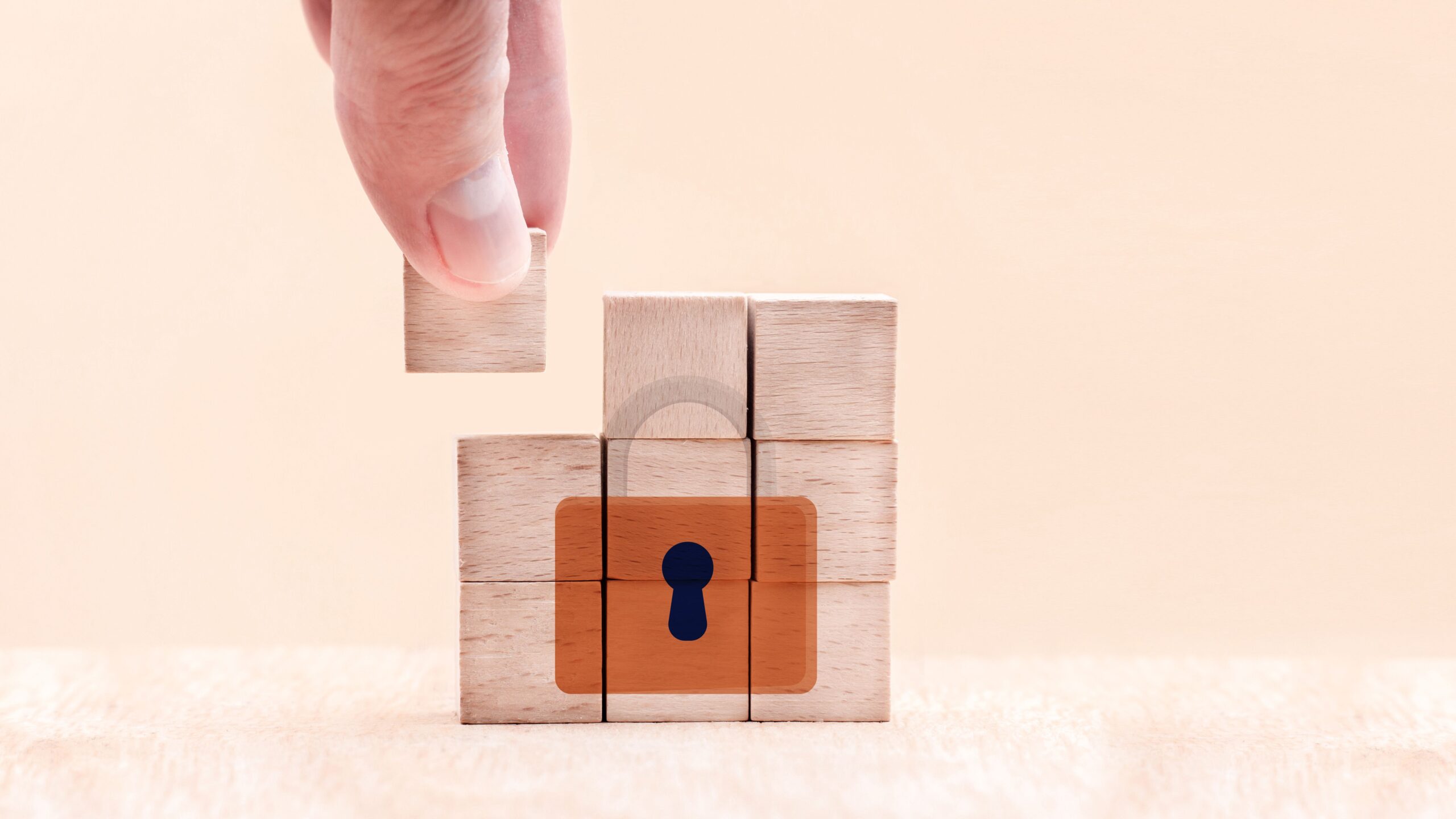 Hand putting the last piece of a wooden puzzle with a key